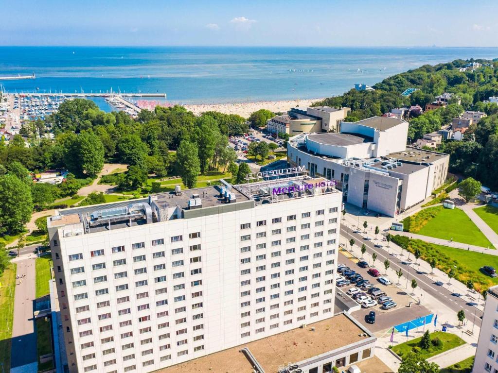 Draufsicht auf ein weißes Gebäude und das Meer in der Unterkunft Mercure Gdynia Centrum in Gdynia
