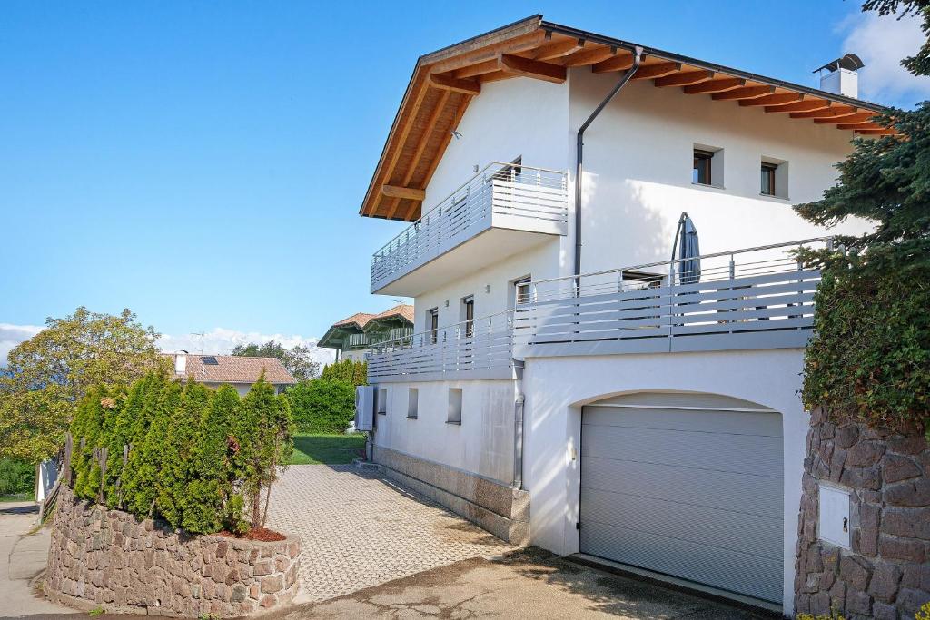 a white house with a garage at Villa Reny in Meltina