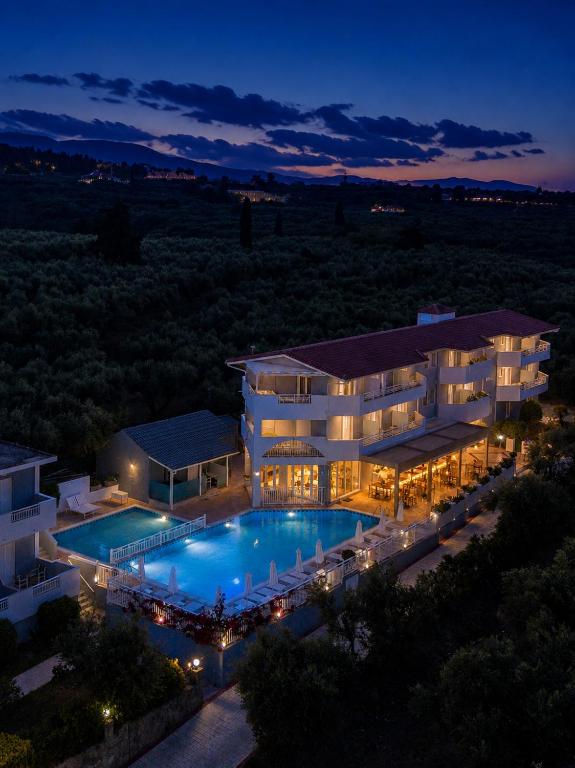 a large building with a swimming pool at night at Zante Pantheon Hotel in Tsilivi