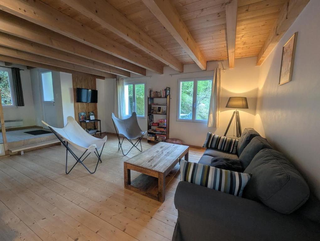 a living room with a couch and chairs and a table at De l'onde au vert in Vivey