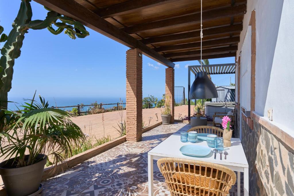a patio with a table and chairs and the beach at Villa Javier in Torrox