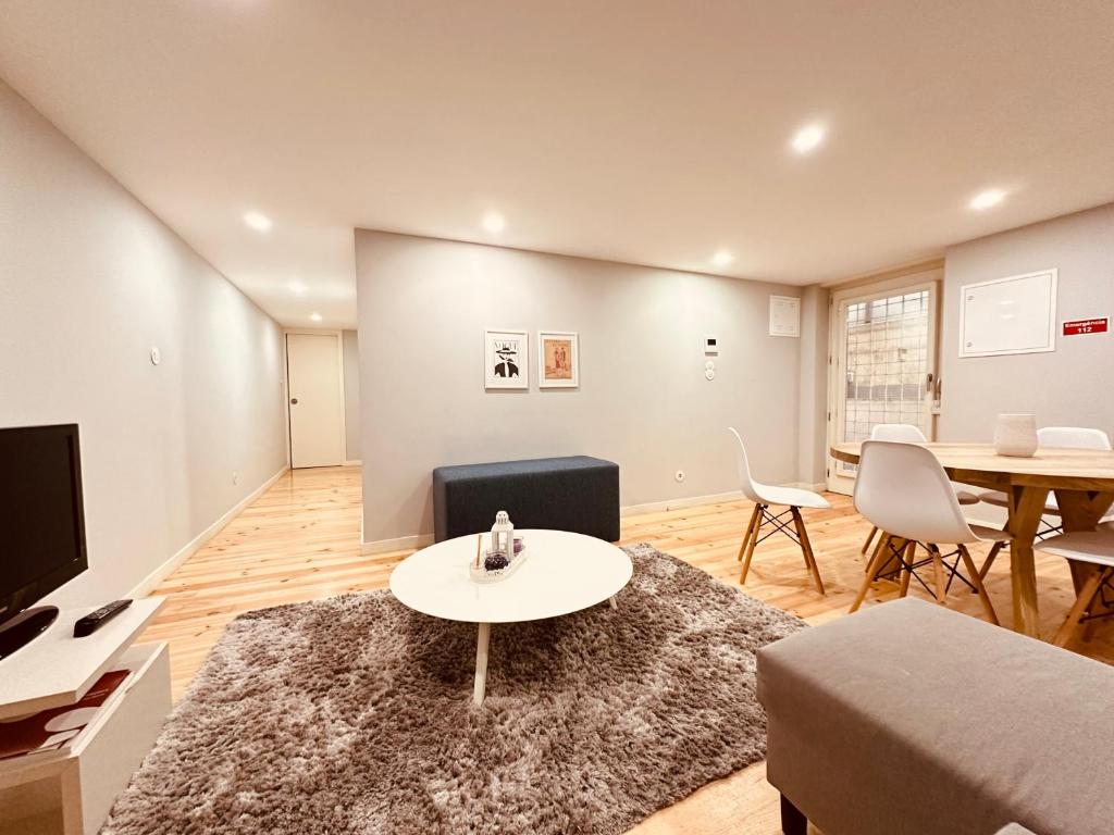 a living room with a couch and a table and a tv at Torrinha's Backyard in Porto