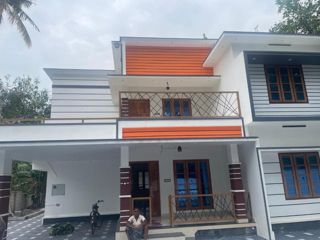 a woman standing in front of a house at Cozi Rooms in Varkala