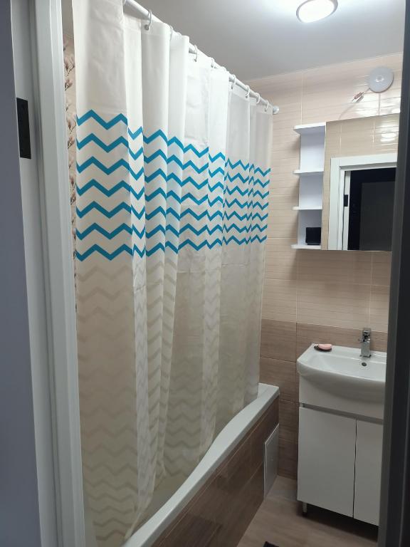 a bathroom with a shower curtain and a sink at Центр,Апартаменти на Байди Вишневецького,97 in Cherkasy
