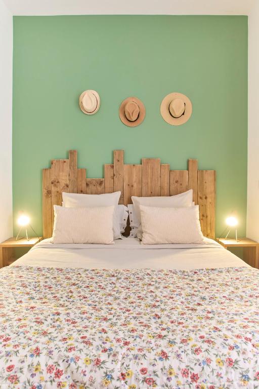 a bedroom with a large bed with two hats on the wall at Abri du vent, chambres et appartements in Fitou