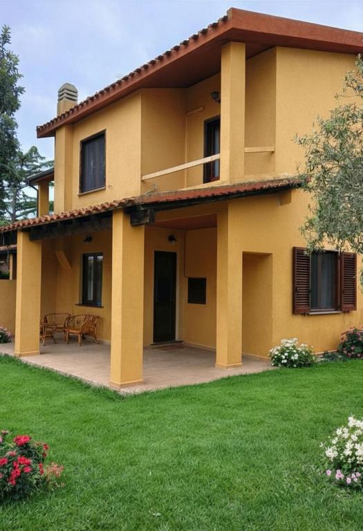 a large yellow house with a patio at Casa Misè in Poggio Dei Pini