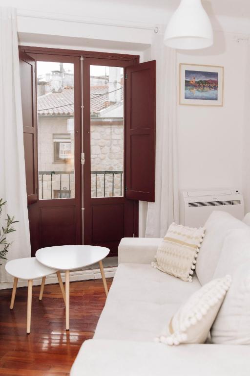 a living room with a white couch and a table at Encanto do Lima Guest House By Lethes Legacy in Ponte de Lima