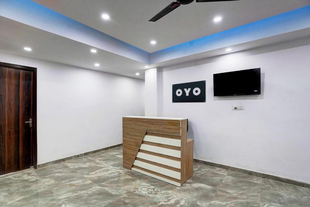 a room with a tv on a white wall at Hotel O The smart haven in Ghaziabad