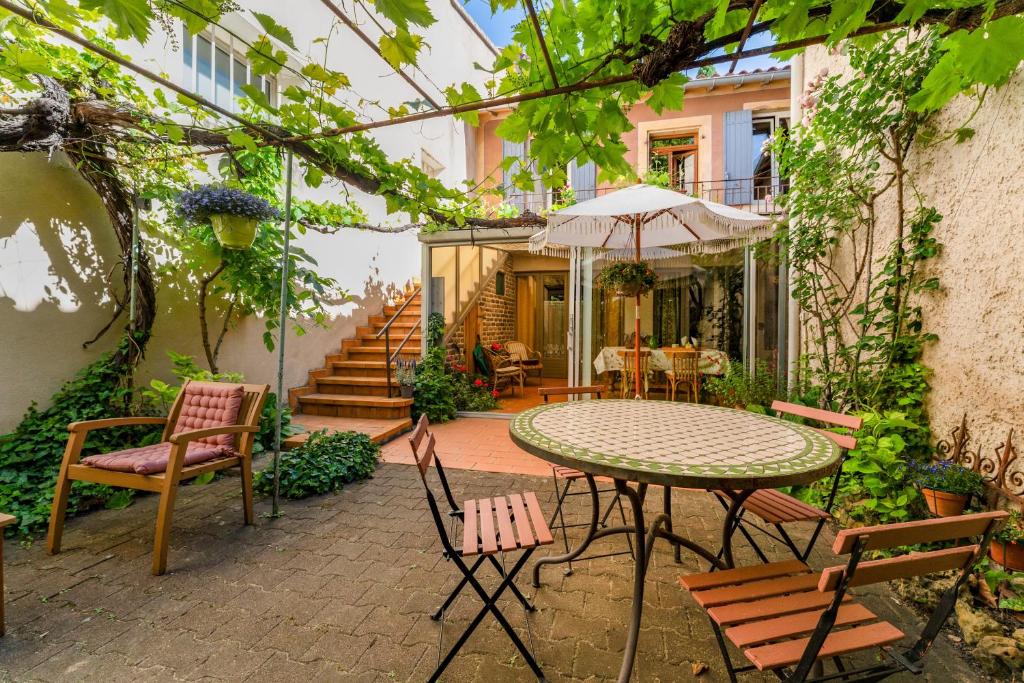 an outdoor patio with a table and chairs and stairs at Côté Jardin in Bédoin