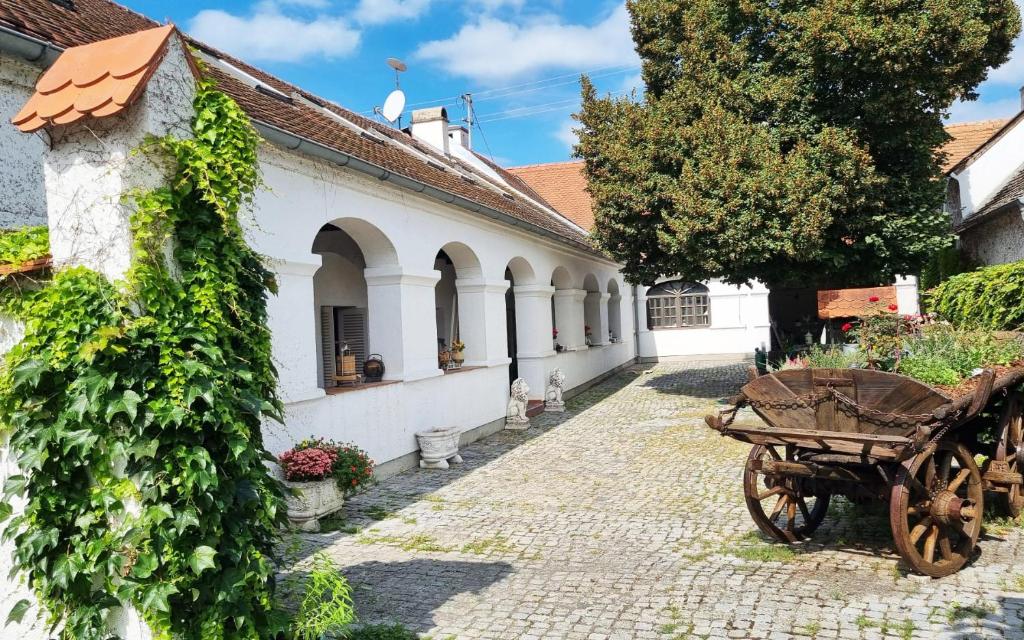 an old cart sits outside of a building at Ferienwohnungen Proschahaus in Eisenberg an der Pinka