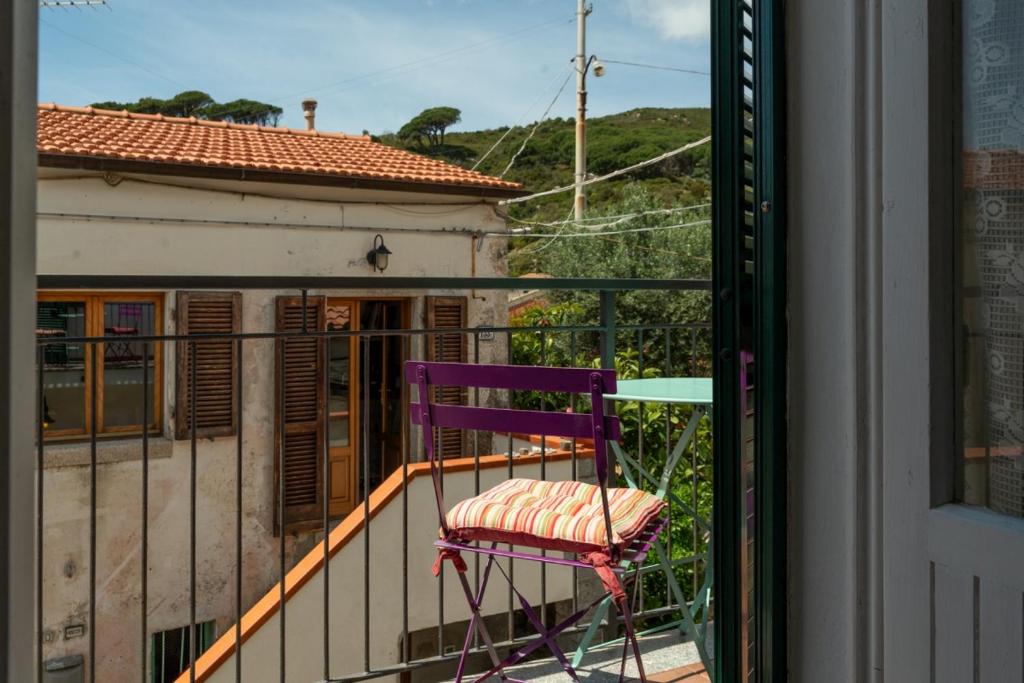 a purple chair sitting on top of a balcony at Le Cote di Seccheto - Goelba in Seccheto