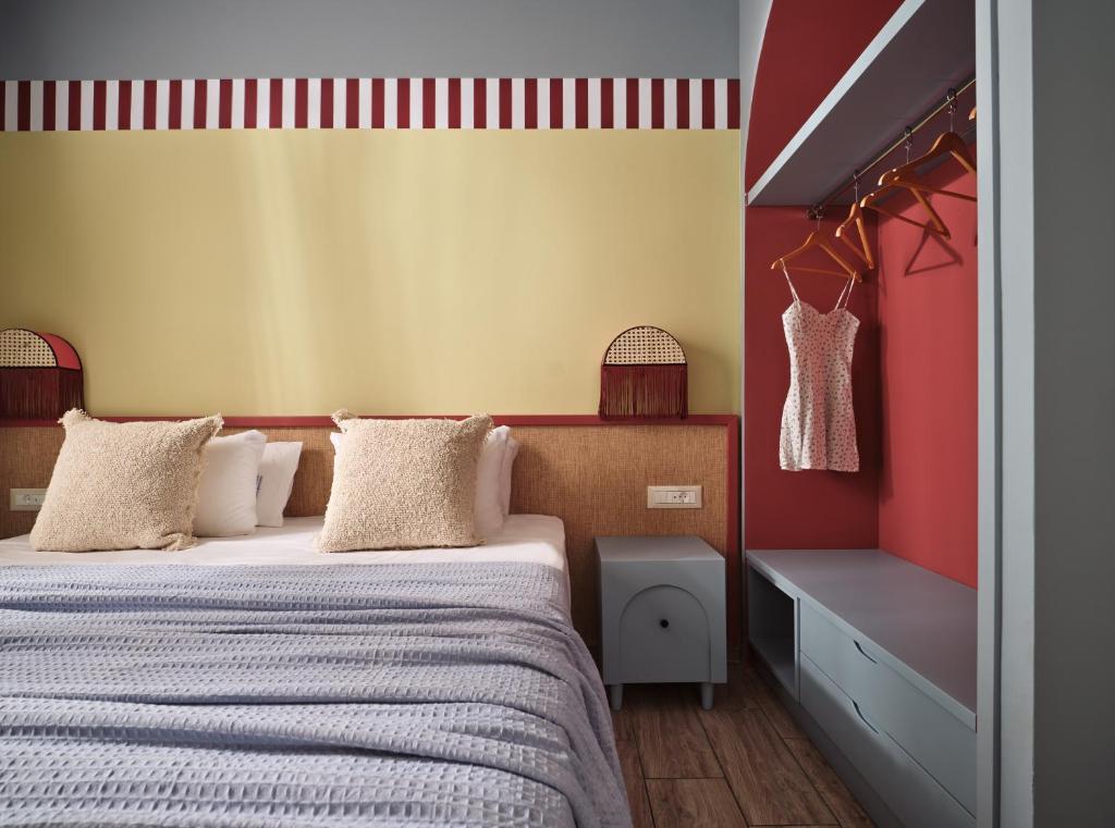 a bedroom with a bed and a yellow and red wall at Memories Apartments - Explore & Recharge in Laganas