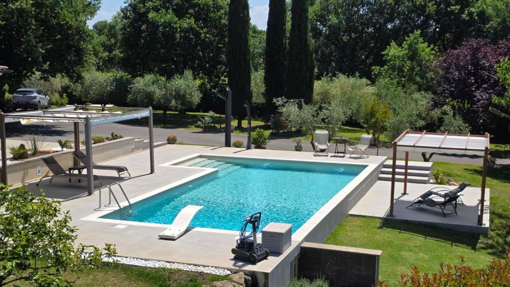 a swimming pool in a yard with two chairs at Oltre la Siepe Apartment in Nepi