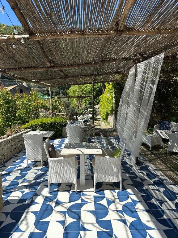 a patio with a table and chairs on a blue and white floor at Aquarius Maiori B&B in Maiori