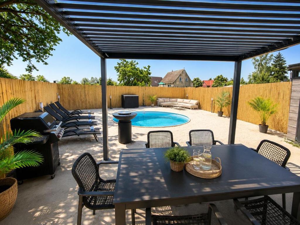 a patio with a table and chairs and a swimming pool at Lara Beach & Resort in Zepkow