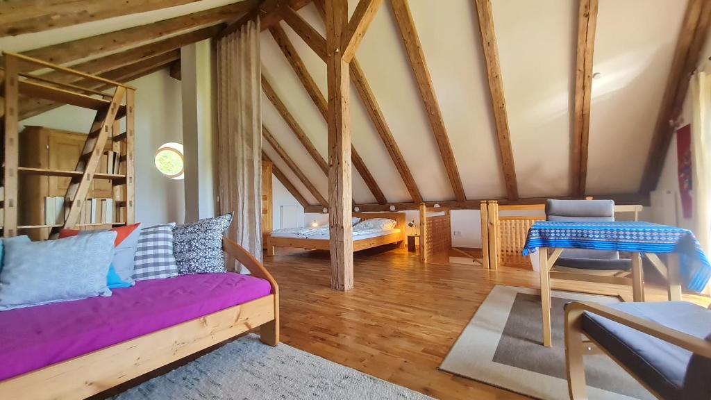 a living room with a purple couch and a table at Helles Landhaus auf Waldlichtung in Dießen am Ammersee