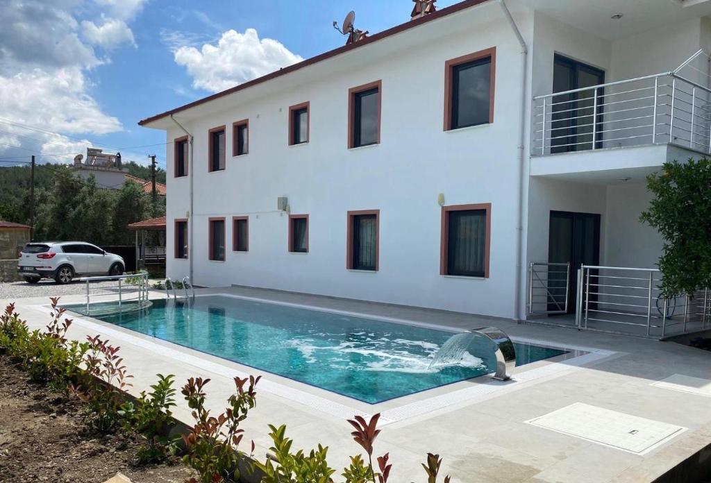 a house with a swimming pool in front of it at Muğladaki Eviniz in Muğla