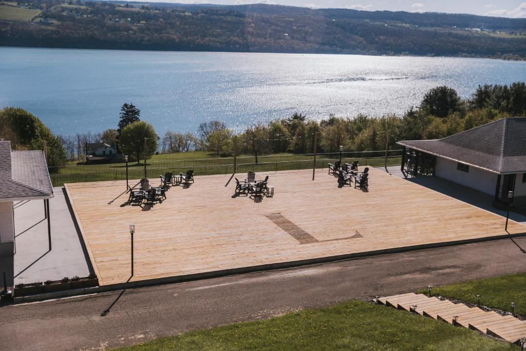 a group of tables and chairs on a large deck with a lake at The Hotel Laurel at Seneca in Watkins Glen