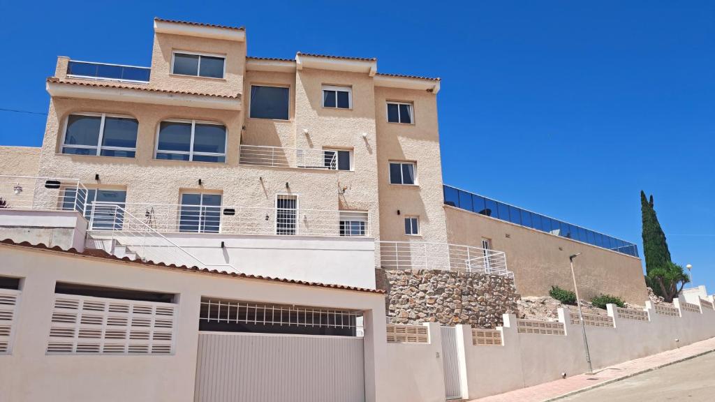 an apartment building with a fence in front of it at Casa Las Vistas in Bolnuevo