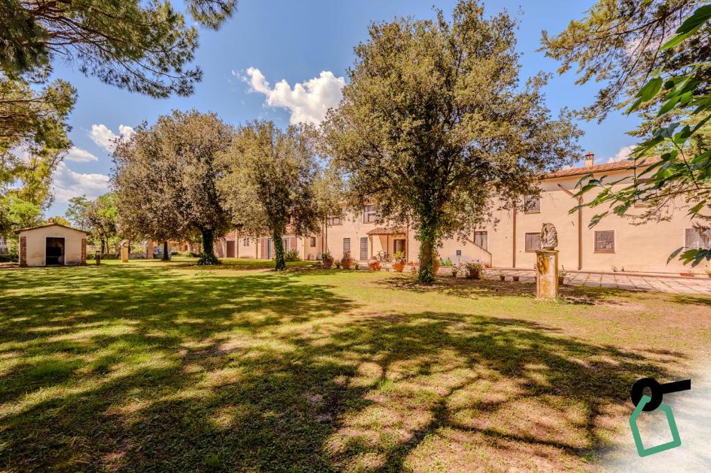 a large building with trees in a yard at Hotiday Grosseto Podere in Grosseto