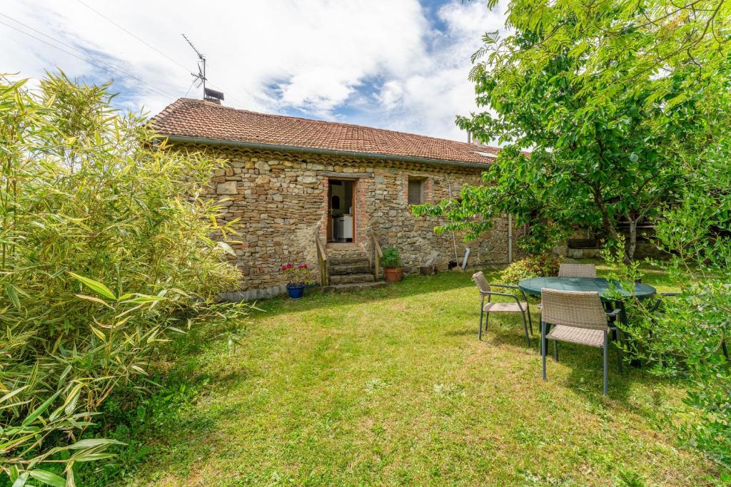 a small house with a table and chairs in the yard at Le Mas Perdu Gîte Studio Parme in Saint-Christol-lès-Alès