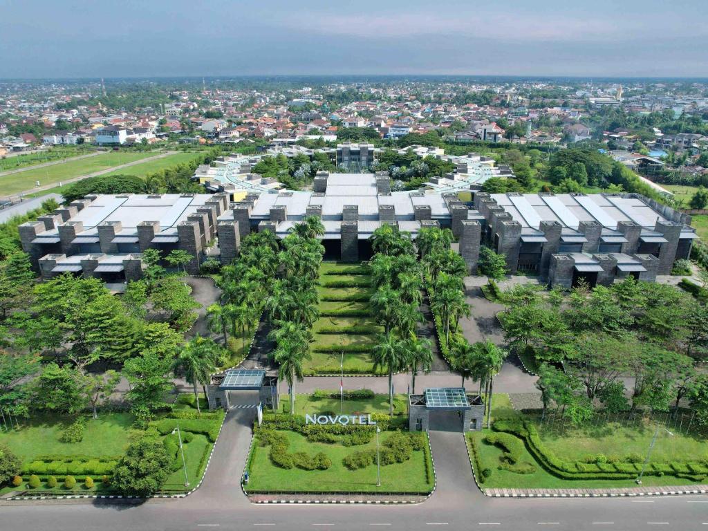 an aerial view of a building with trees in front at Novotel Palembang in Palembang