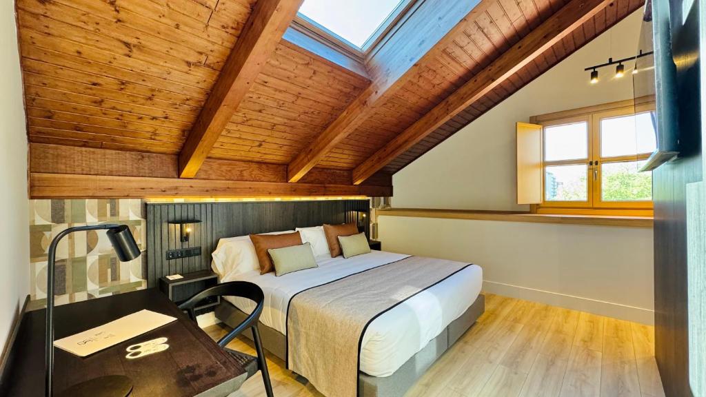 a bedroom with a bed and a desk and a window at Soho Boutique La Harinera in Valladolid