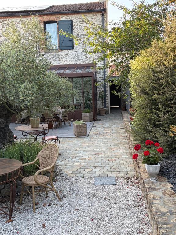 a patio with a table and chairs and flowers at Céline et Olivier in Pornic