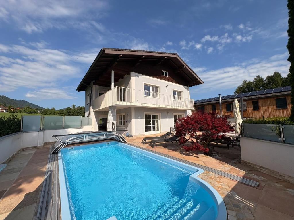 a house with a swimming pool in front of a house at Panorama Haus am Traunsee in Traunkirchen