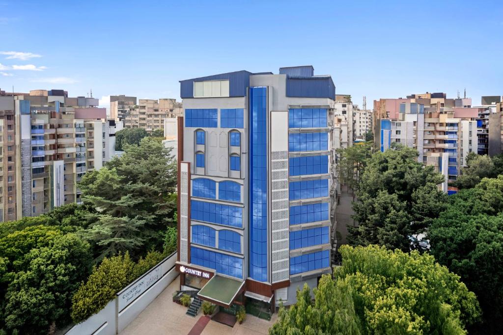 a tall building with blue windows in a city at Country Inn Smart Stays, Patna in Patna