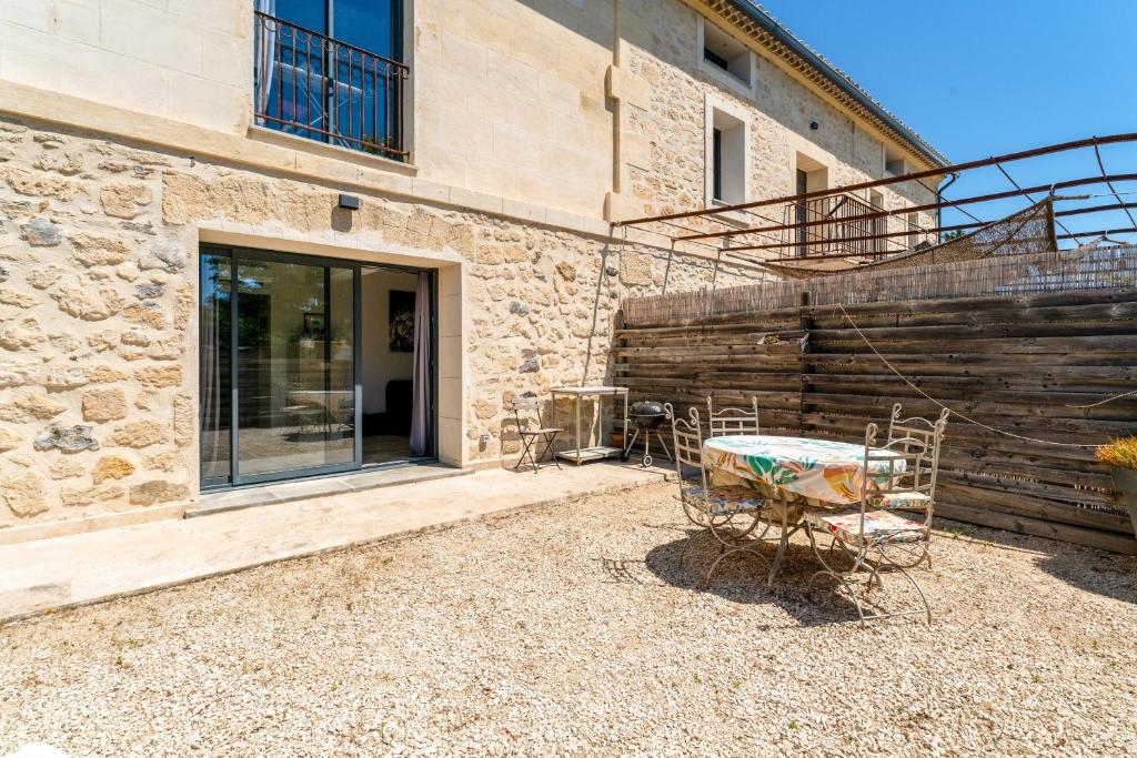 a patio with a table and chairs in front of a building at Mas Delorme 1 in Arles