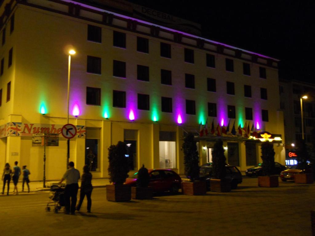 a building with green and purple lights on it at Hotel Bistrita in Bacău