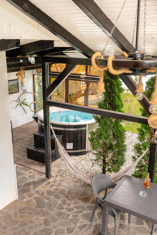 an outdoor patio with a hammock and a hot tub at Cabana Diana in Avrig