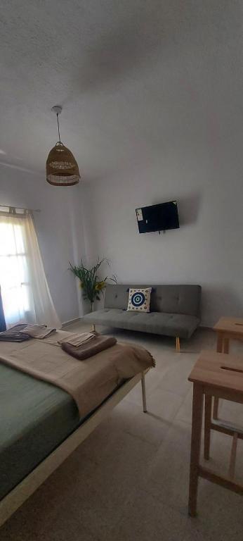 a bedroom with a bed and a couch and a tv at MUSHROOMs1 AFYTOS in Afitos