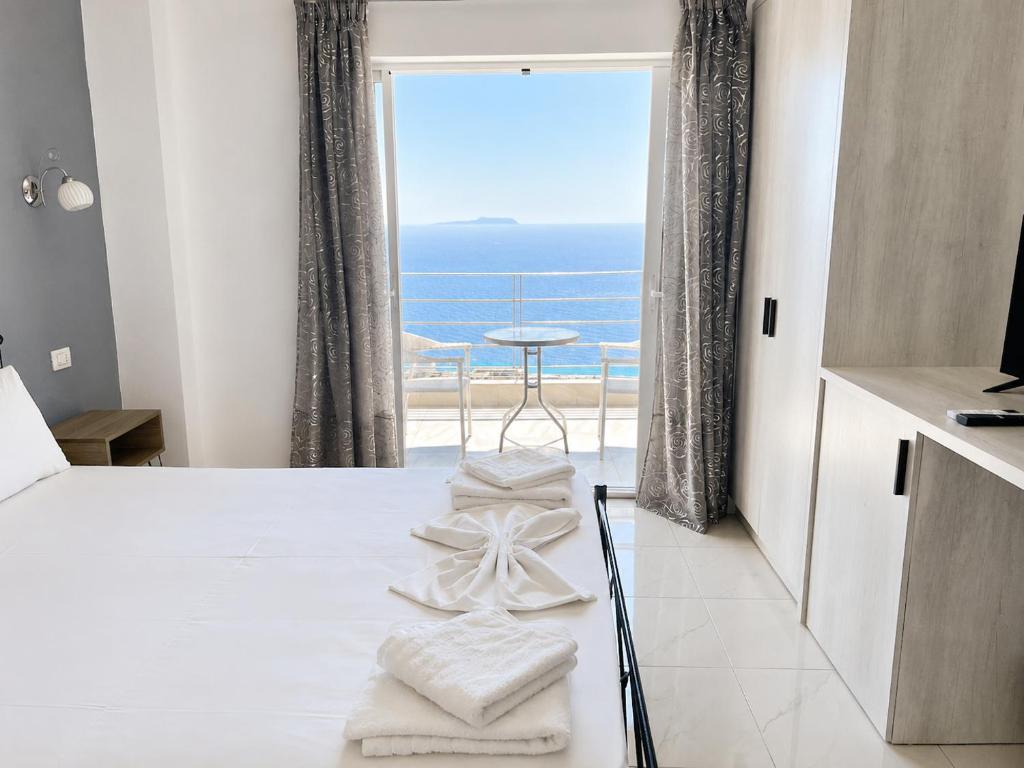a bedroom with a bed and a view of the ocean at Palasa View in Dhërmi