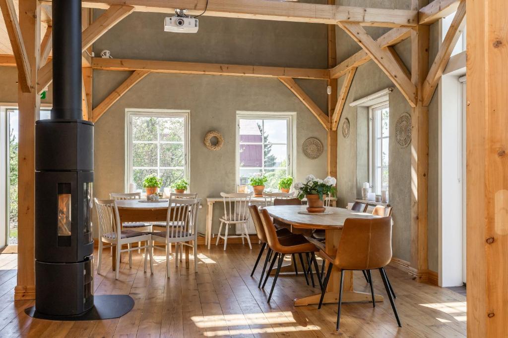 a room with tables and chairs and a wood stove at Allsta Gård in Bjärtrå