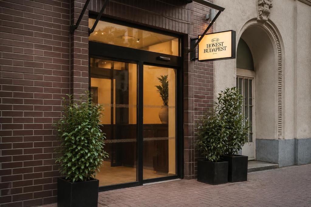 a building with two potted plants in front of a store at Honest Budapest by chic&basic in Budapest