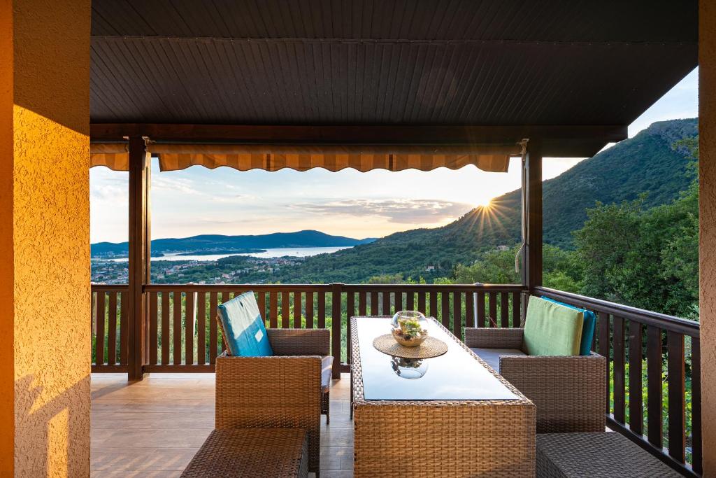 a patio with a table and chairs on a balcony at Sunset Holiday Home in Tivat
