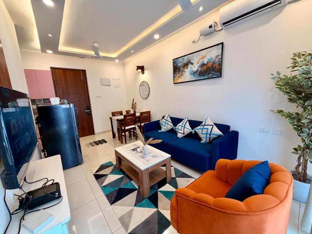 a living room with a blue couch and a table at THE DUIN 1BR Apt Amoret Homes in Chicalim