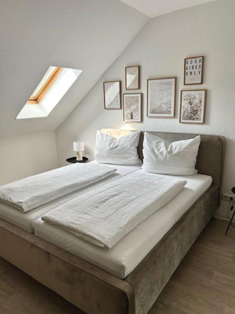 a bedroom with a large bed with white sheets and pillows at Haus Knechtel in Stadtallendorf