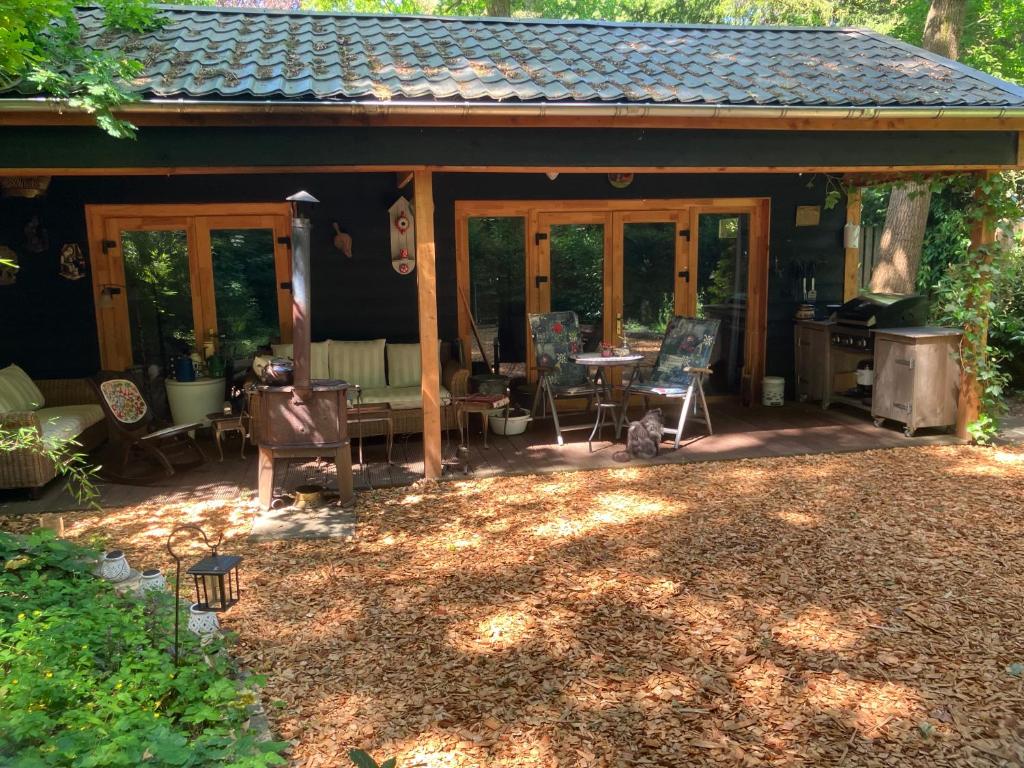a screened in porch of a house with a table and chairs at Berghut in Doorn