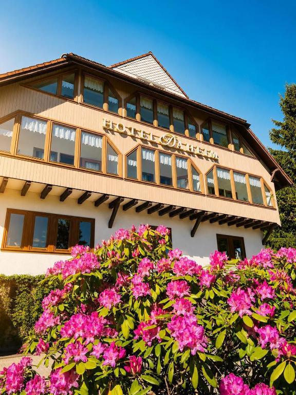 ein Gebäude mit rosa Blumen davor in der Unterkunft Hotel Daheim in Gehlberg