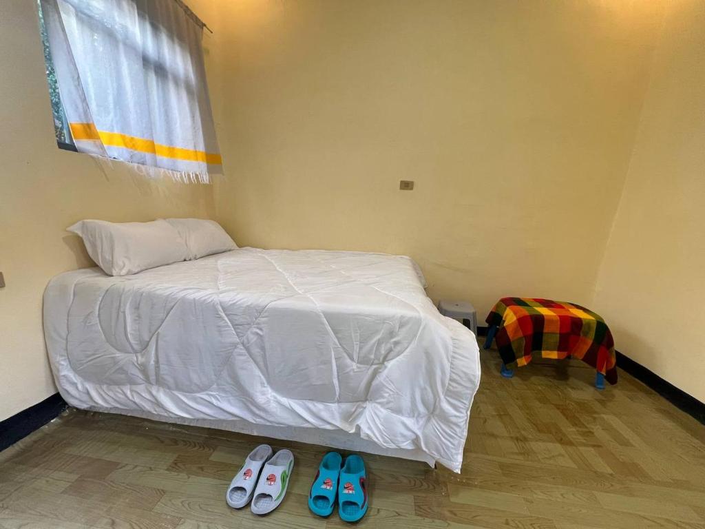 a bedroom with a bed and two pairs of slippers at Addis View Homestay in Lalibela