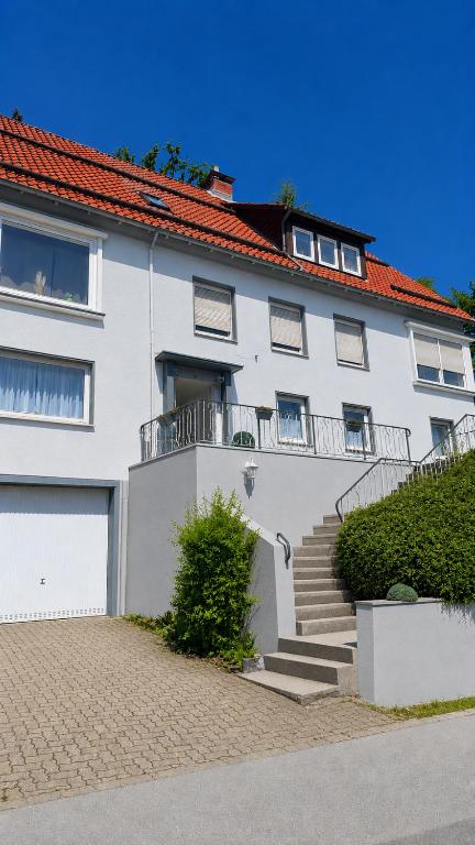 a white house with stairs in front of it at Haus Westharz Goslar in Bad Grund