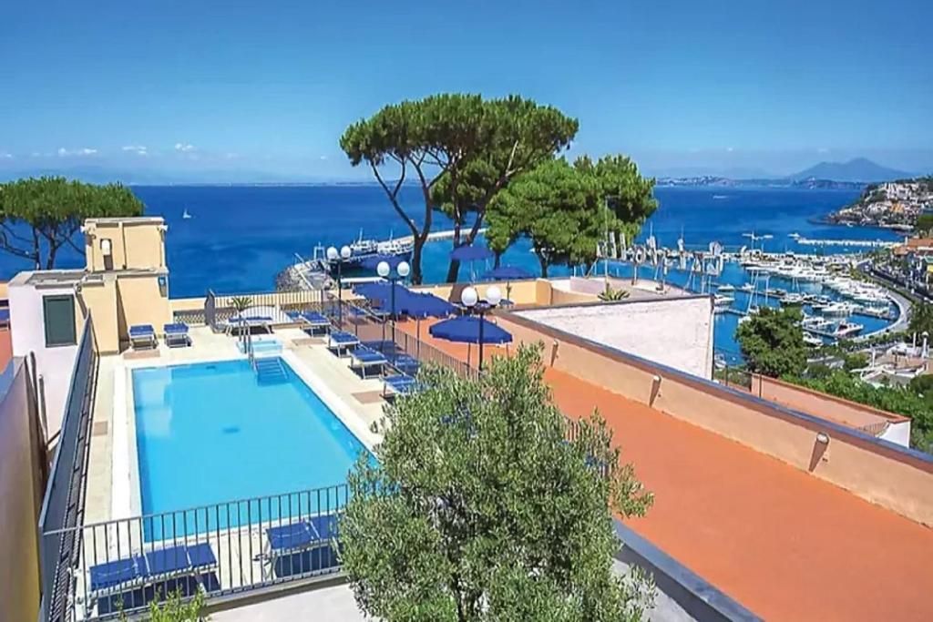 a resort with a swimming pool and a view of the ocean at Hotel Terme Cristallo Palace in Casamicciola Terme
