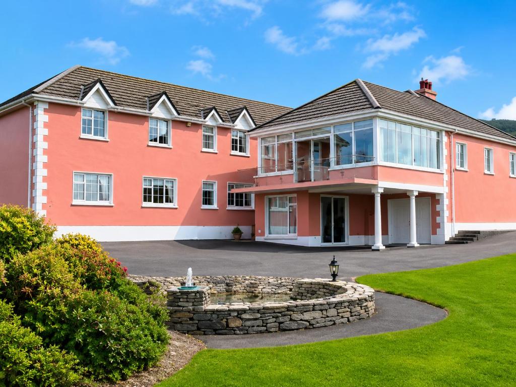 a large orange house with a yard at Renard Lodge in Cahersiveen