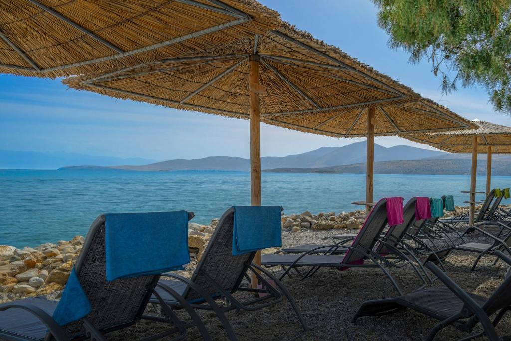 a group of chairs and umbrellas on a beach at Kalafatis Garden House in Itea