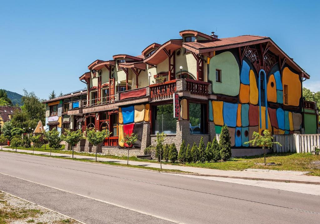 ein farbenfrohes Gebäude an einer Straßenseite in der Unterkunft Hotel Áčko in Ružomberok