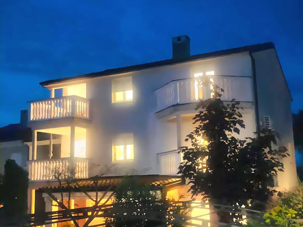 a large white building with lights on at night at Apartments Basic Sveti Anton 88 in Malinska