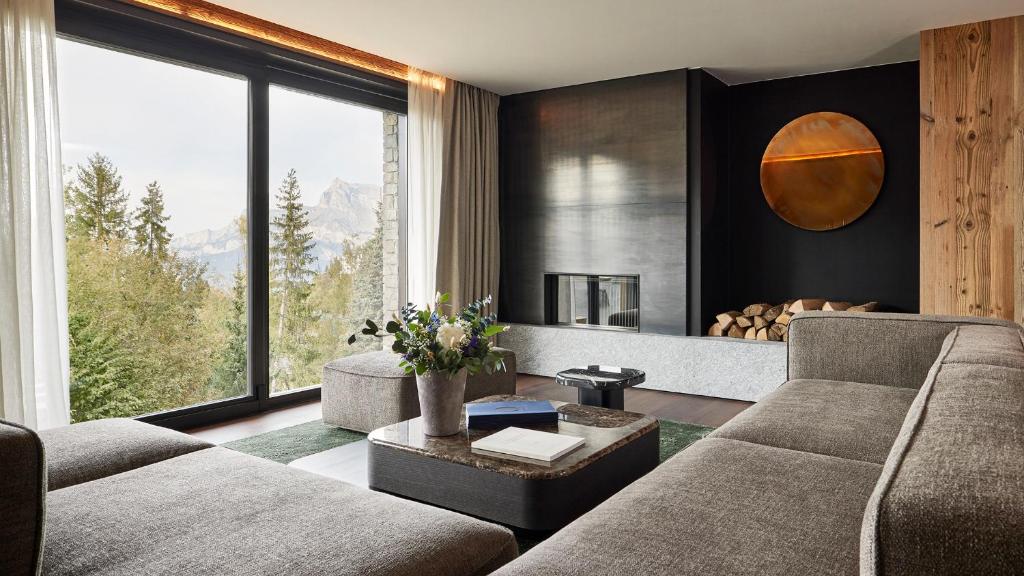a living room with two couches and a large window at Les Chalets de l'Observatoire in Megève